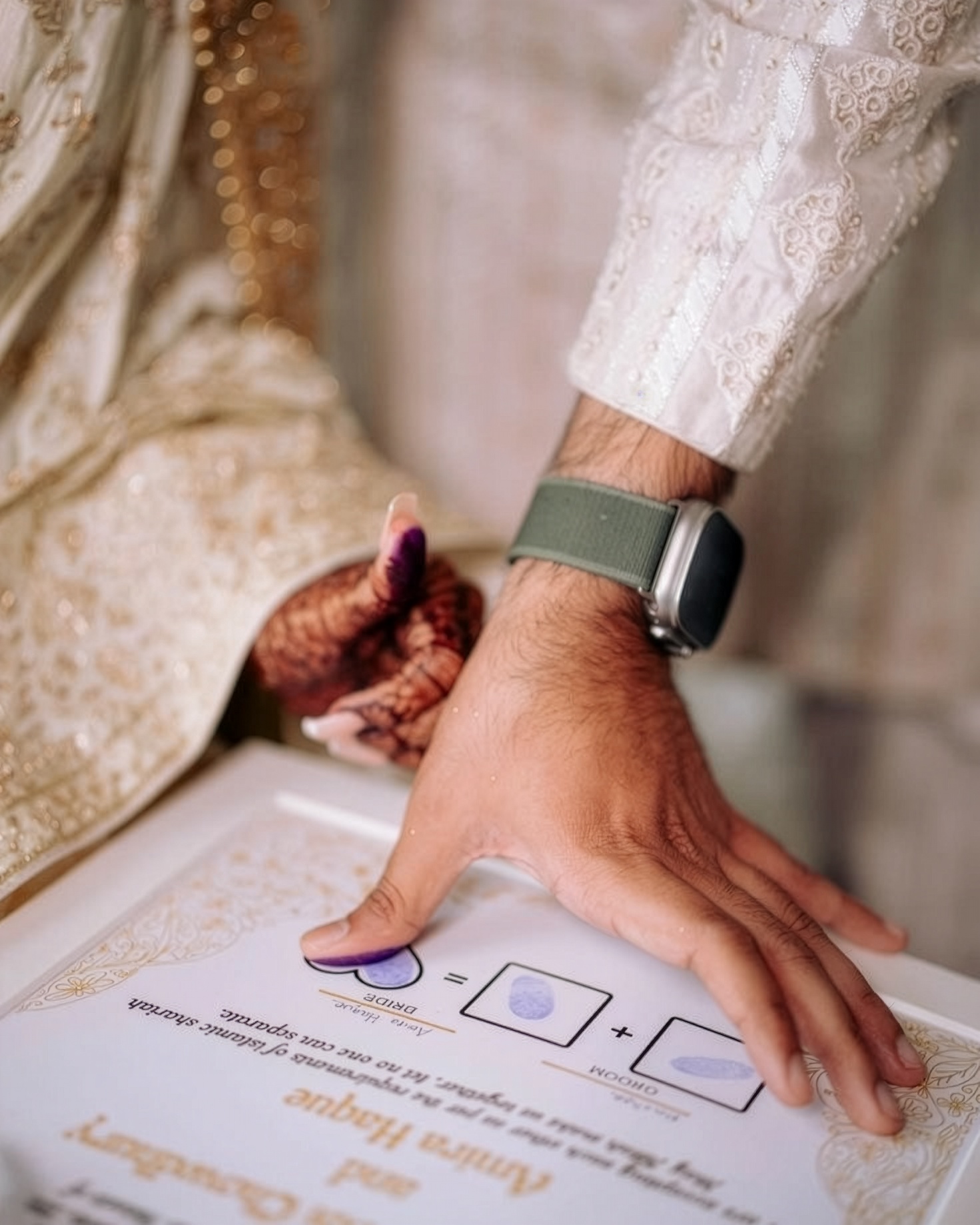 The couple placing their thumbprints on the marriage certificate